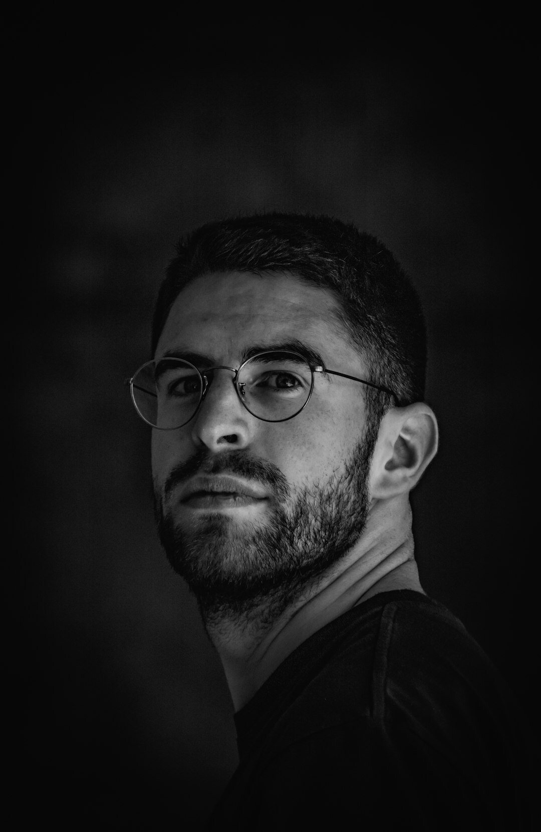 Portrait of a man with short beard and glasses
