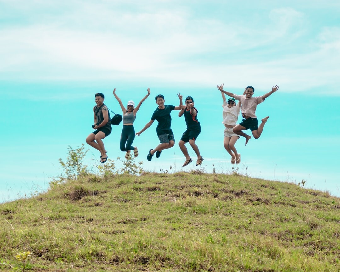 Group of diverse colleagues jumping joyfully outdoors