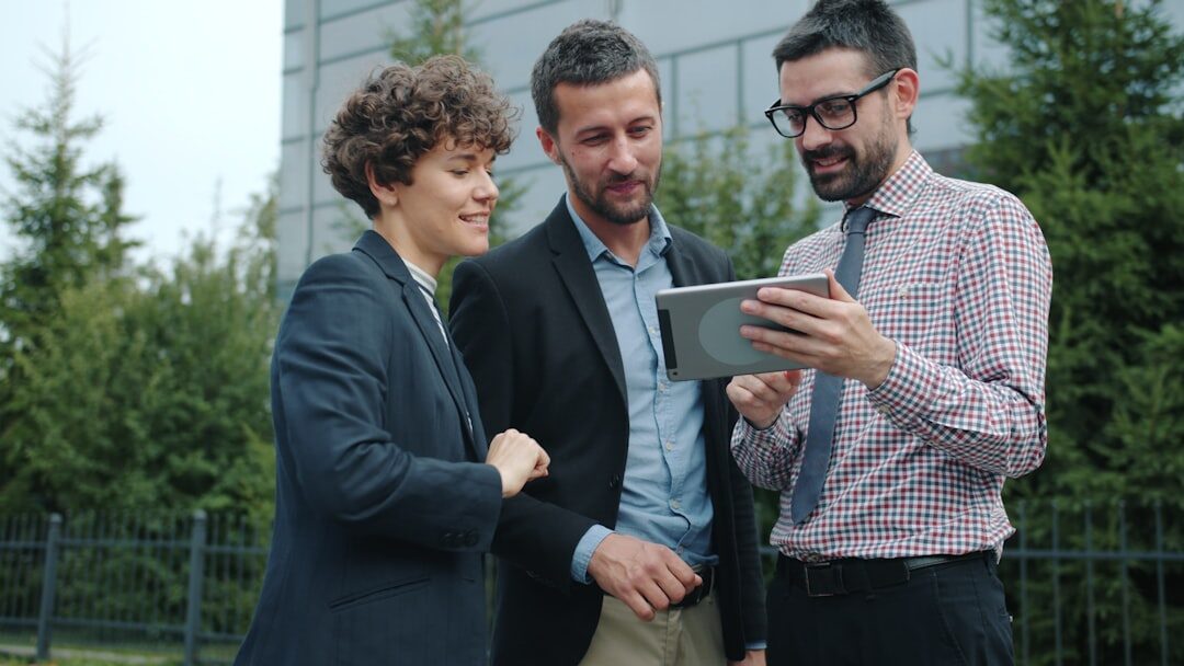 Small group of colleagues discussing around a laptop outdoors