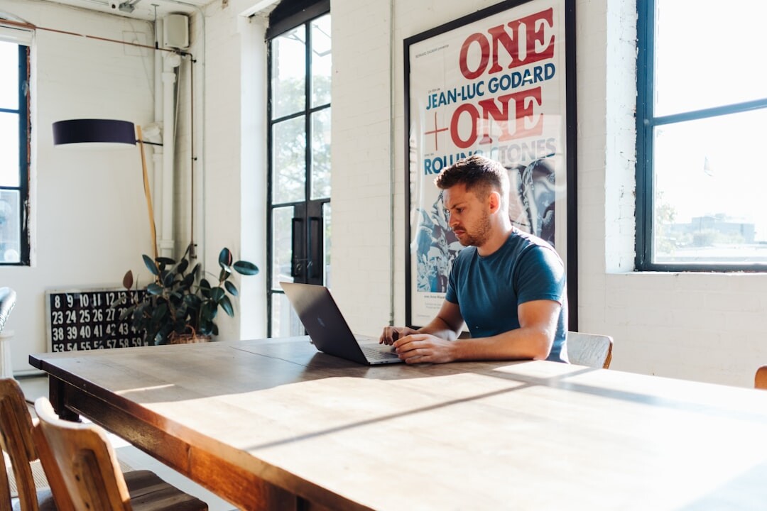 Man working on a laptop in a bright office